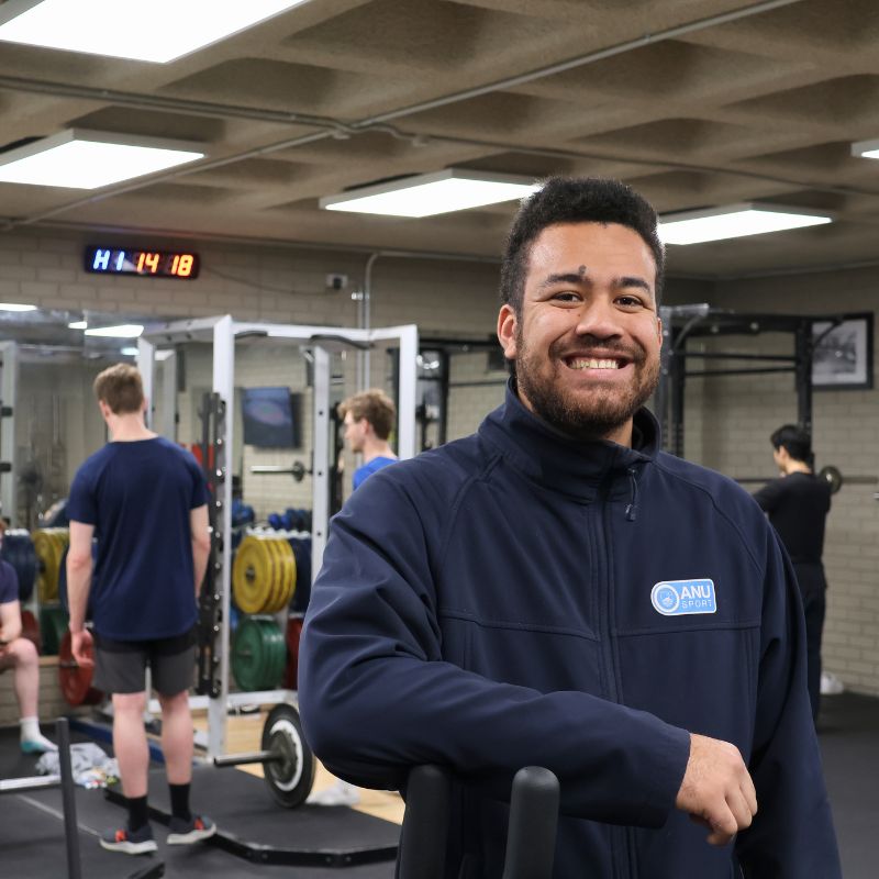 Trainer in gym smiling at camera
