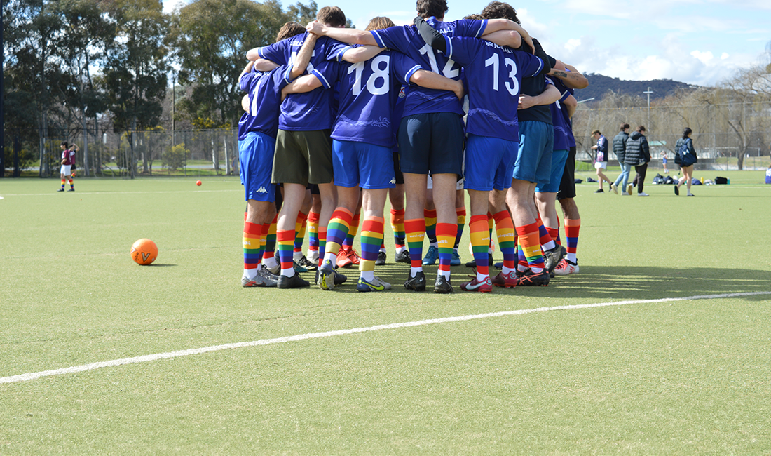 Team standing in circle wearing rainbow socks